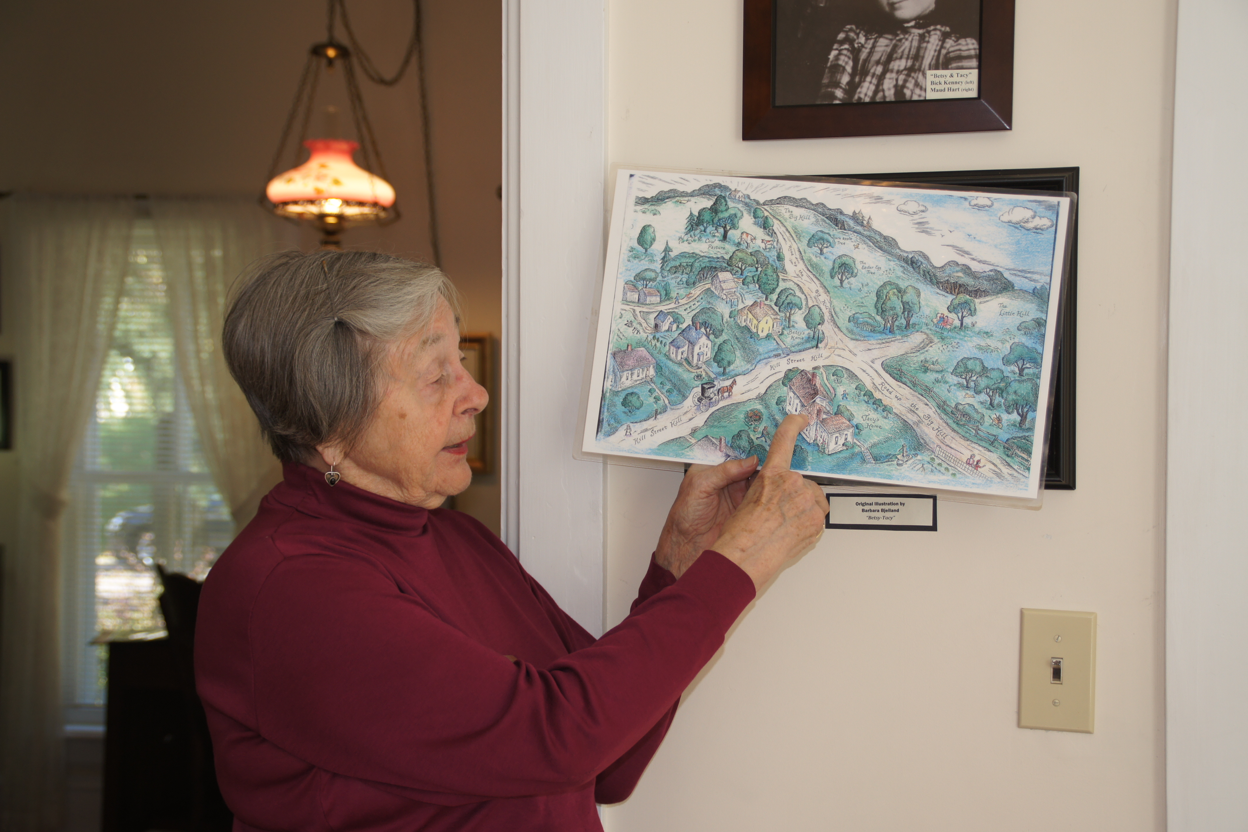 Docent Kathryn Hansen shows a Lois Lenski illustration of the Betsy-Tacy books and compares it to the neighborhood today.